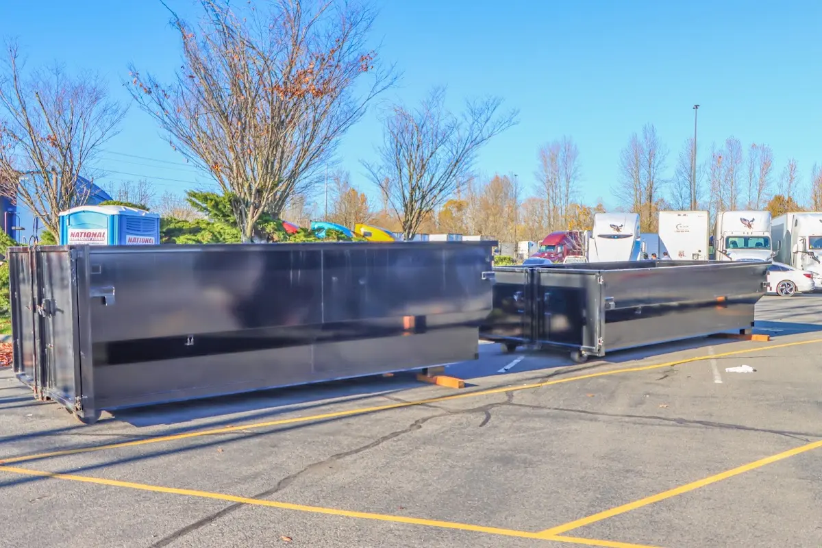 Professional dumpster rental service with roll-off container on residential driveway in Navasota